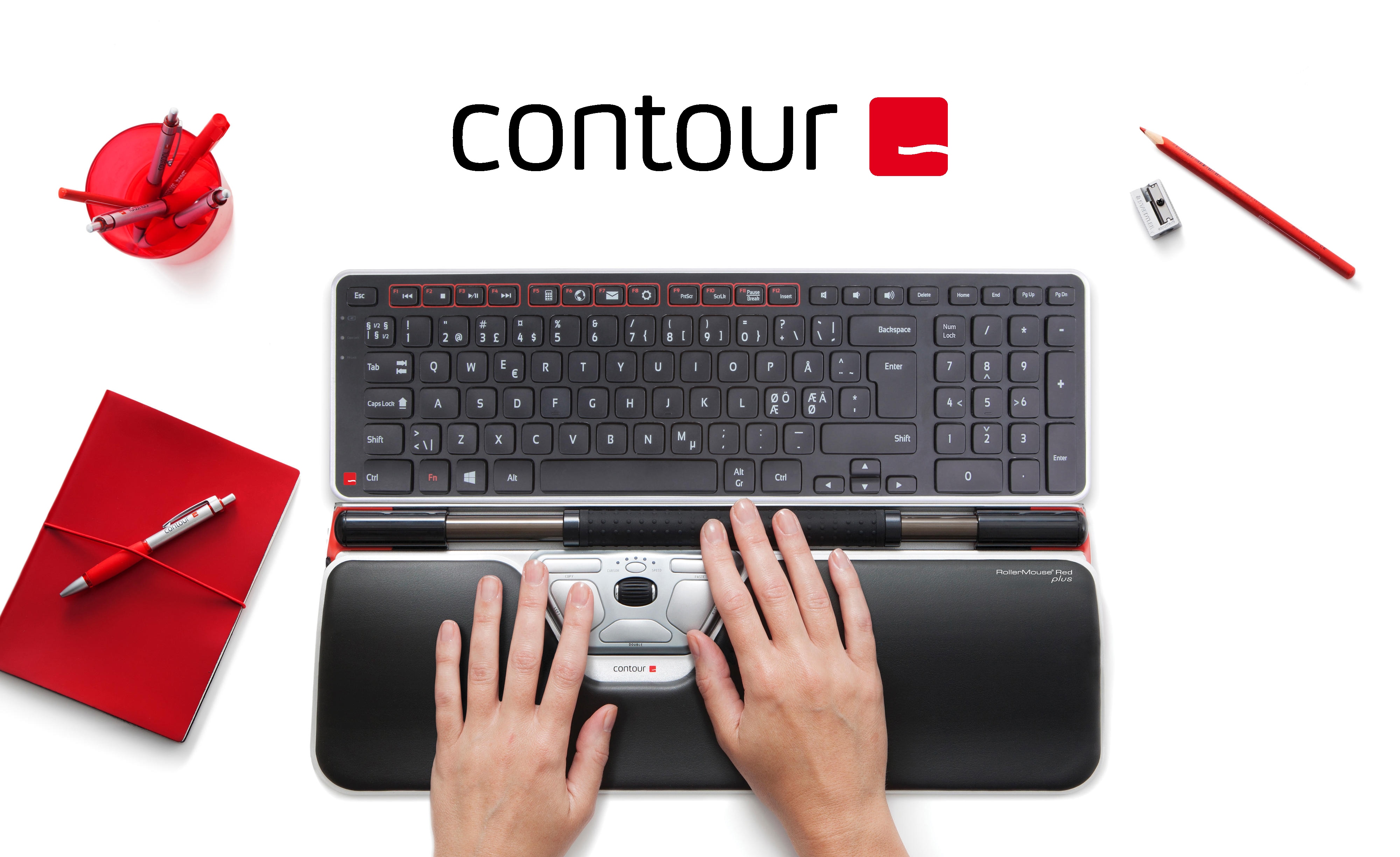 Contour tilbehør på et hvidt bord ved siden af en computer skærm og røde kontorartikler