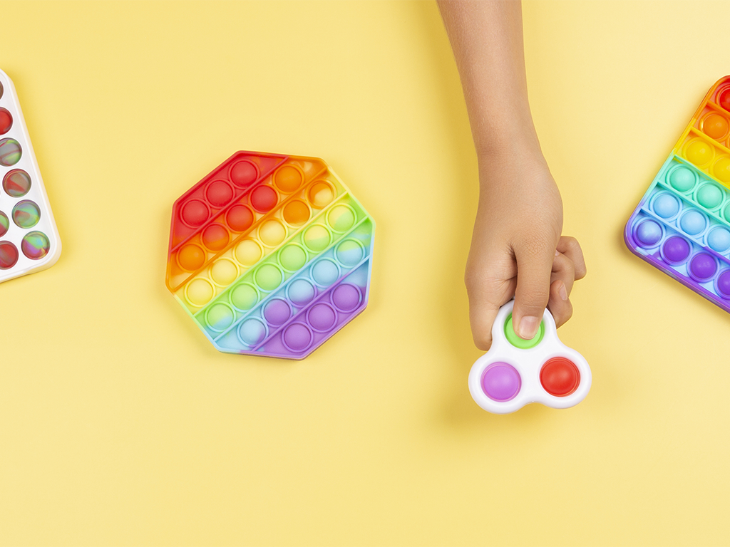 Mange farvefulde fidget toys, inklusiv fidget spinner og pop it fidget toy