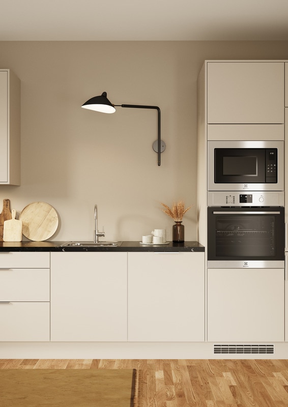 Hvidt EPOQ-køkken med sort bordplade, hvidevarer og lampe i et åbent køkkenmiljø
