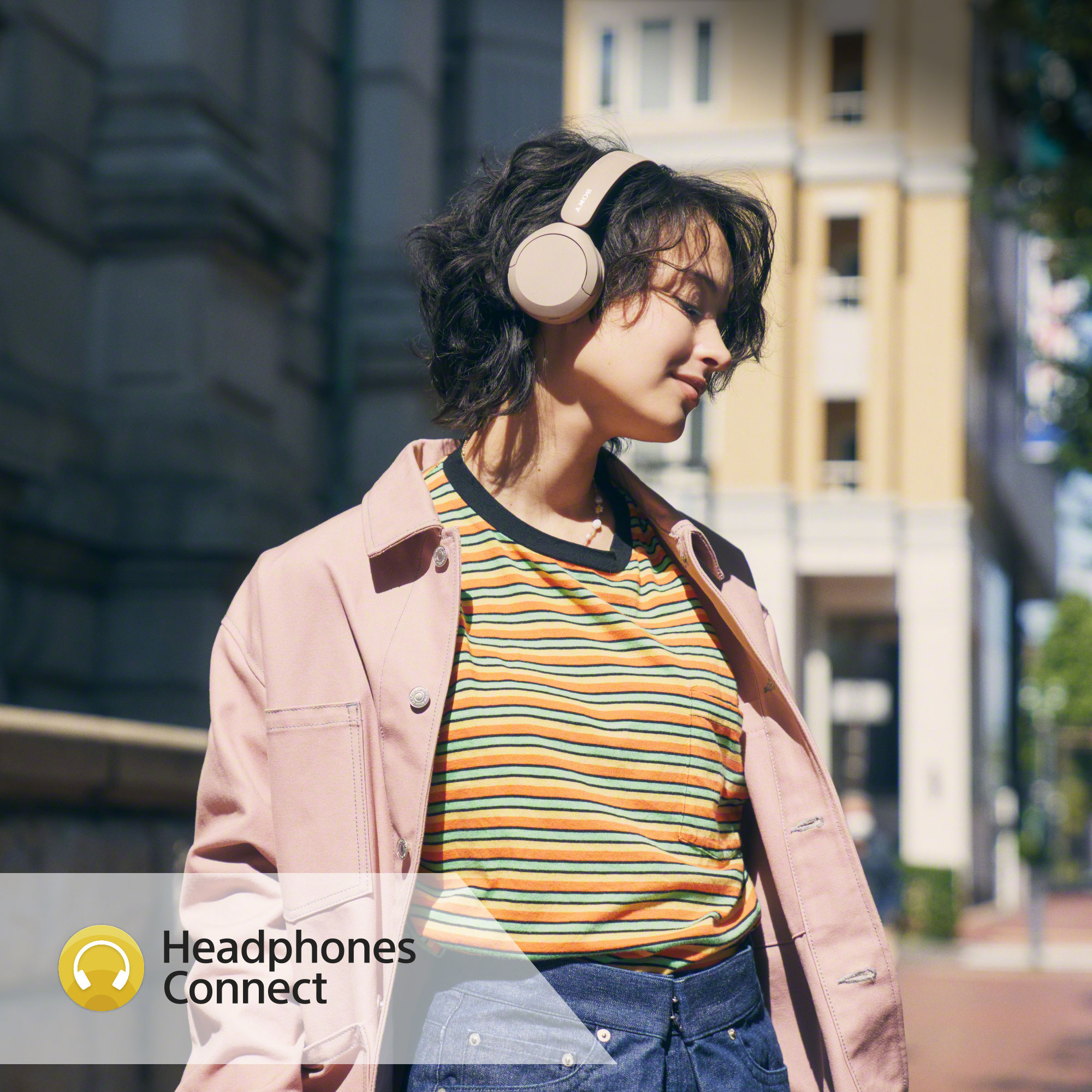 Girl in the street wearing Sony WH-CH520 headphones and listening to music