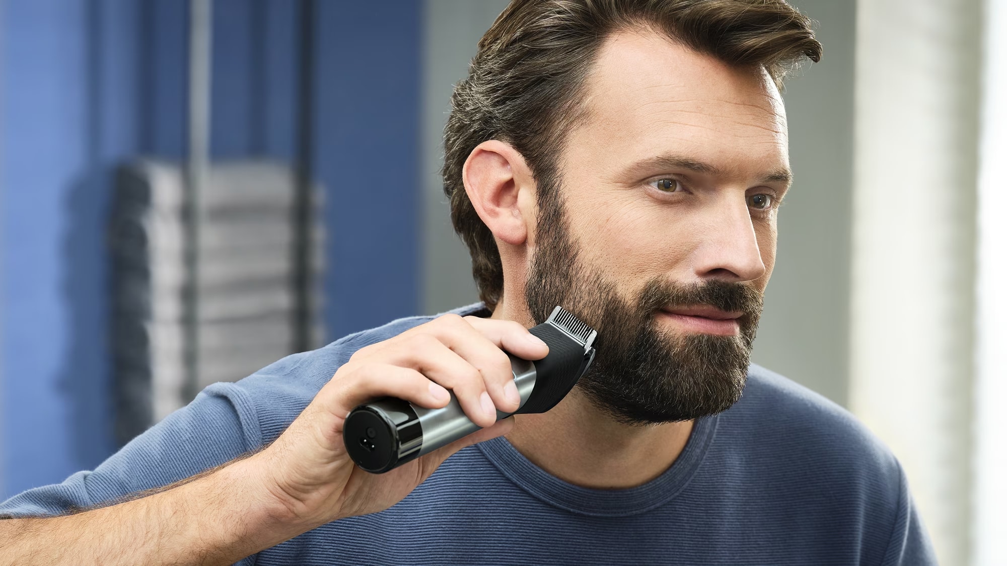Mand der barberer sit skæg med en trimmer