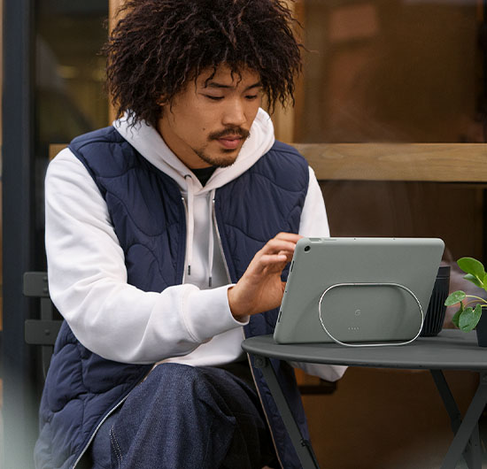 Mand sidder udenfor og bruger Google Pixel Tablet