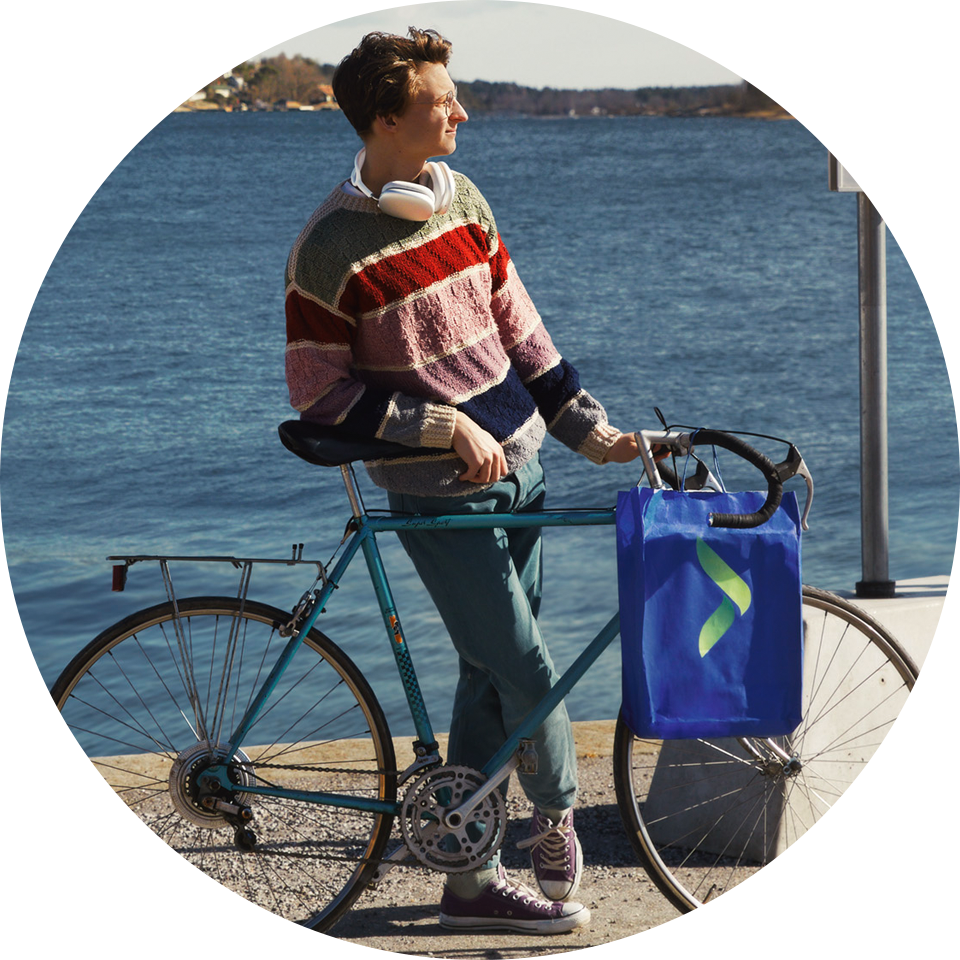 Ung person med en cykel med en Elgiganten-pose på styret