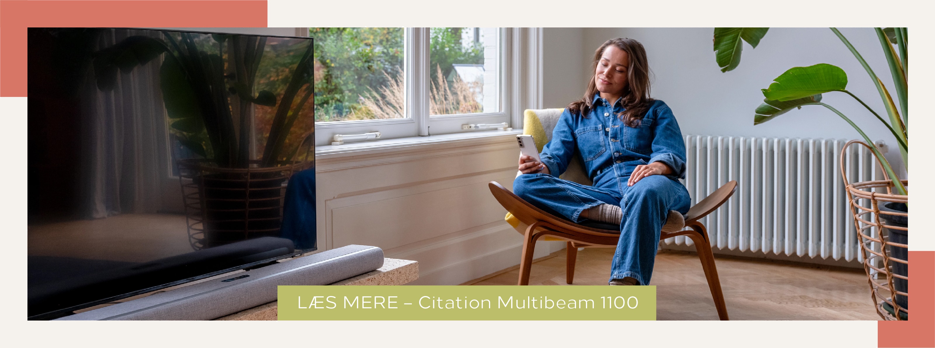 Kvinde der sidder i en stue ved siden af et TV og Harman Kardon Citation Multibeam 1100