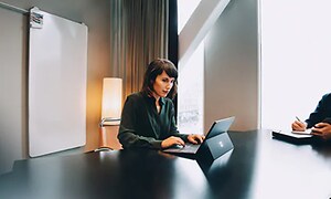 Kvinde der bruger windows PC i et mødelokale