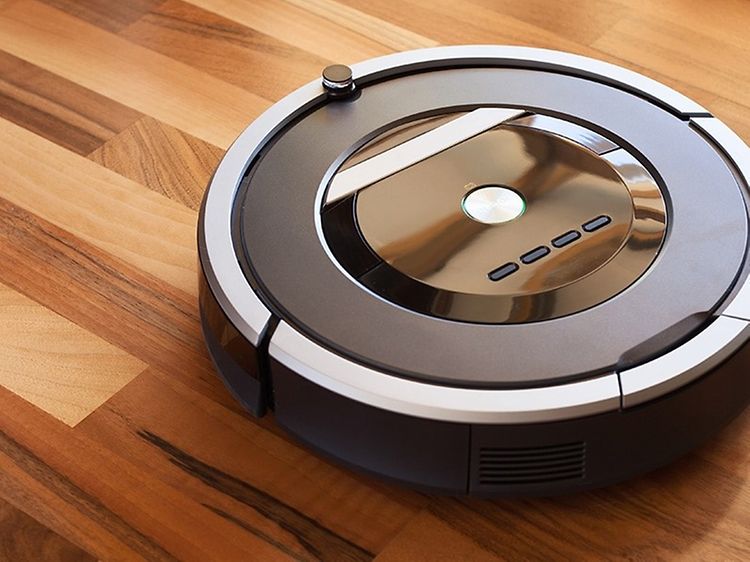 Sort robotstøvsuger på et trægulv