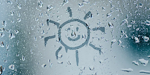 smiley drawn on a window covered in thaw