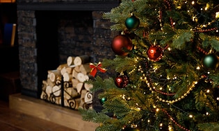Pyntet juletræ foran pejs