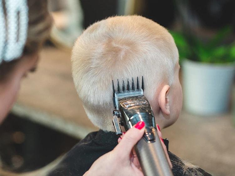 kvindelig frisør klipper en ung dreng