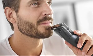 Mand der  trimmer sit skæg med en Philips Series 7000 trimmer