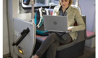 working woman on the train with her HP laptop