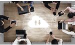 Syv personer omkring et bord arbejder sammen via cloud-lagring