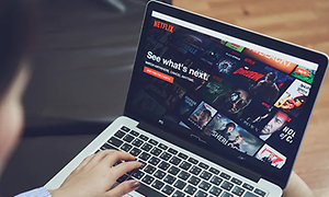 Person der ser Netflix på en bærbar