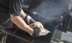 Mand der røger på en gas grill