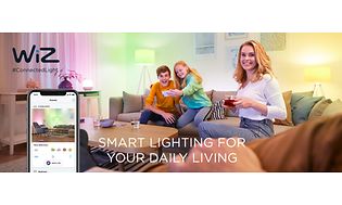 En familie sidder i en sofa og styrer lamperne via en app