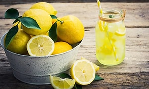 Billede af citroner og en forfriskende lemonade på et bord