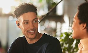 Sony WF-1000XM4 i ørerne på to, der taler sammen