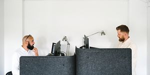 To mænd på et kontor, der arbejder på hver deres computer