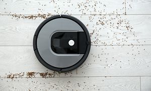 Robotstøvsuger, der støvsuger over et hvidt gulv