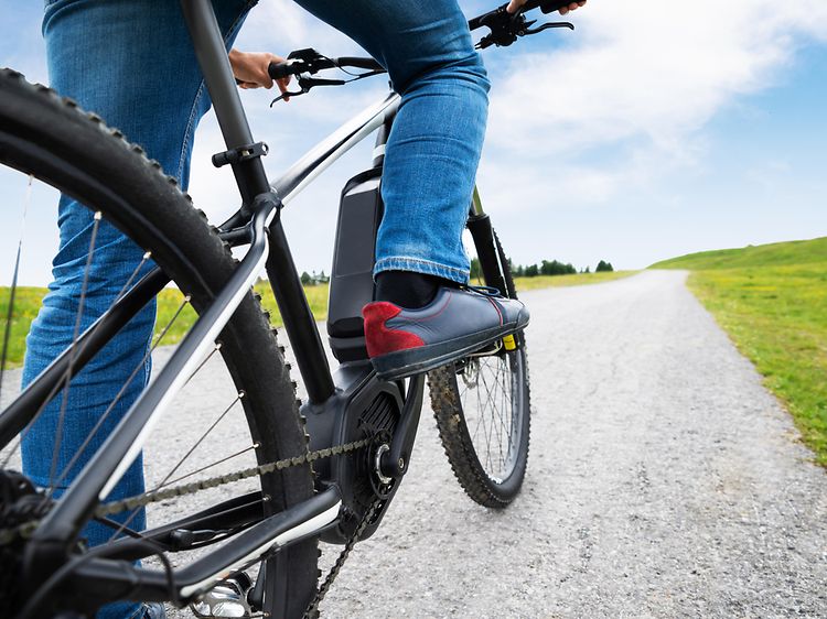Person på en elcykel ude på landet.