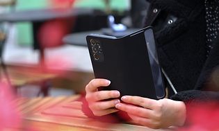 Samsung Galaxy-telefon med cover i hånden på kvinde