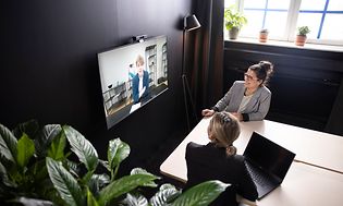 To kvinder deltager i et videomøde med Konftel C2070-systemet