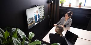 To kvinder deltager i et videomøde med Konftel C2070-systemet