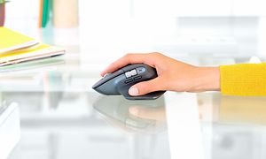Person, der holder en computermus på et pænt skrivebord