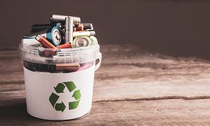 Batterier i en spand med genbrugstegn på