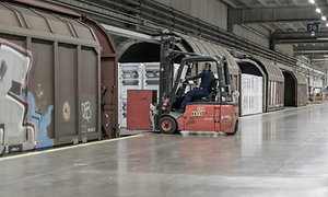 Gaffeltruck kører varer ombord på tog