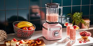 KitchenAid lyserød blender på køkkenbordet med frugt og smoothies