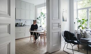 Kvinde, der har hjemmekontor i køkkenet