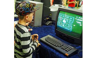 En dreng spiller pac man på et gammelt CRT TV