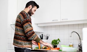 En mand, der laver mad i sit køkken