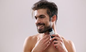 En mand, der trimmer sit skæg med en Philips-trimmer