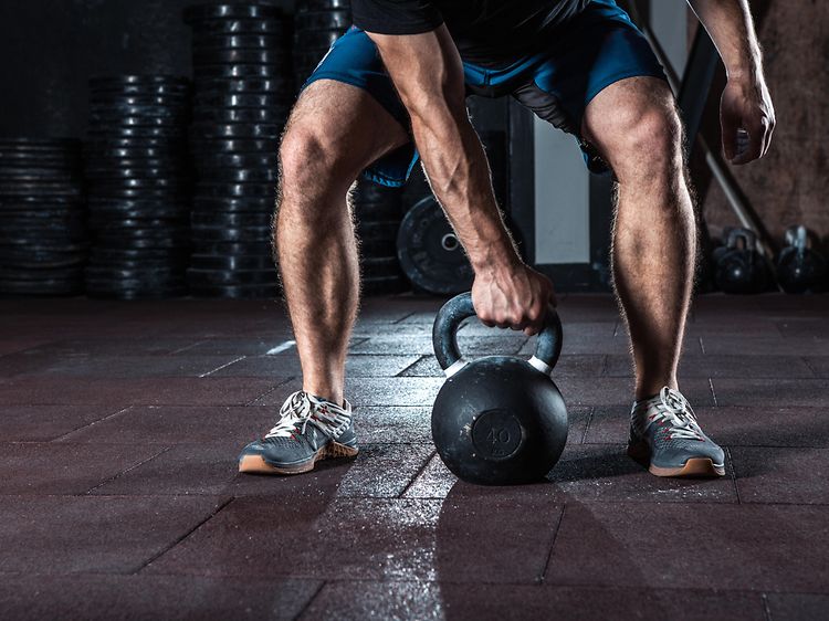 Mand der træner og skal til at løfte en kettlebell