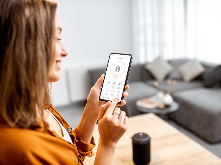 Kvinde der åbner en dør via en app på hendes telefon