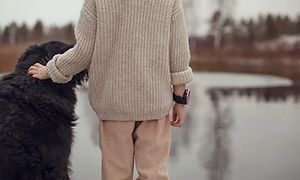 Et barn med Xplora X5 smartwatch, der klapper en hund