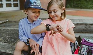 Dreng og pige ser på Xplora X5 smartwatch på pigens håndled