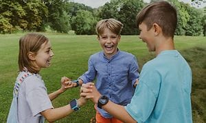 To drenge og en pige med Xplora X5 smartwatches på armene