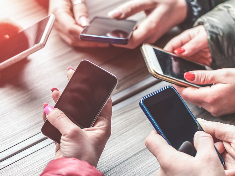 Hænder der holder forskellige smartphones.