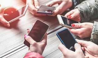 Hænder der holder forskellige smartphones.