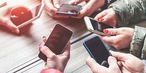 Hænder der holder forskellige smartphones.
