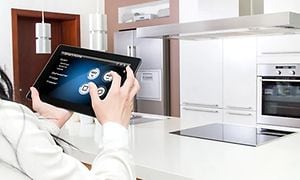 Person, der bruger en tablet til at styre smarte køkkenmaskiner