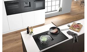 Bosch komfur med integreret emhætte i et moderne køkken med andre Bosch apparater