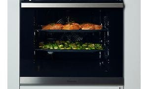 Hisense brand page - Inde i en ovn med bradepander med mad på