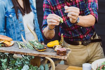 Outdoor kitchen - a man seasoning meat and vegetables