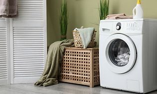 Vaskemaskine i moderne værelse mod grøn væg