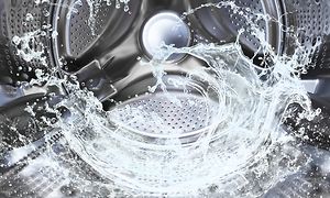 Nærbillede af vaskemaskinetromle med vand i