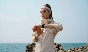 Huawei Watch 3 på armen af kvinde, der træner ved vandet